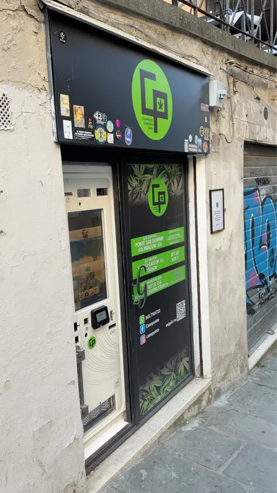 L'ingresso di Canaponte in Via Alessi, con l'insegna verde e il distributore automatico